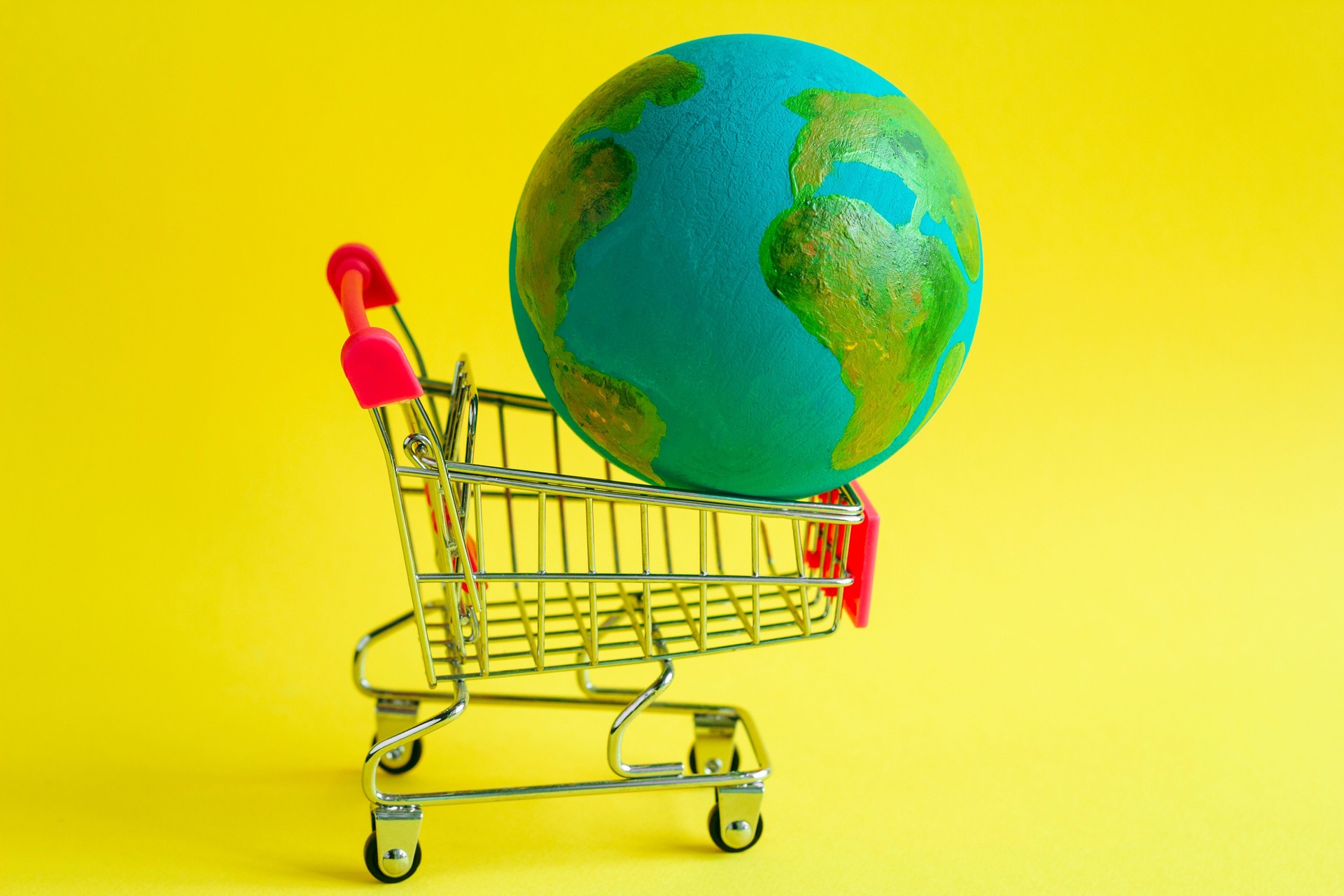 metal shopping cart with a model of the planet Earth inside